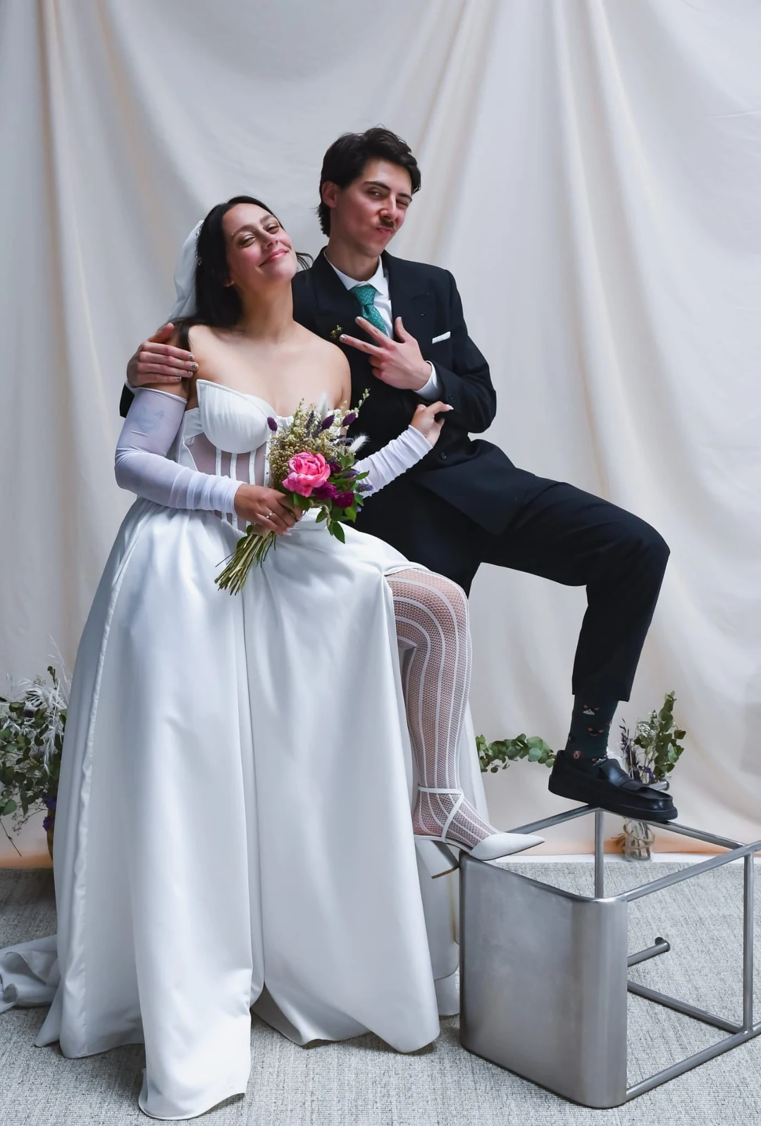 Pareja de novios; la novia con vestido de novia confeccionado a medida